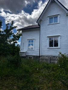a white house with two windows on the side of it at Cozy apartment in quiet neighborhood in Oslo