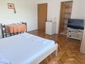 a room with a table and a tv and a table and chairs at Apartments Radulović in Biograd na Moru