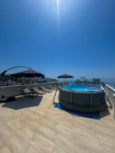 a swimming pool with chairs and umbrellas on a building at Flabelline in Bar