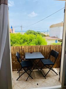 a table and chairs on a patio with a fence at T3 vue mer 100m jardin in Hyères