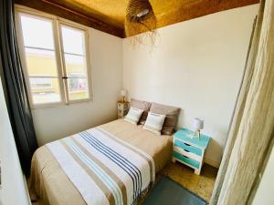 a small bedroom with a bed and a blue nightstand at T3 vue mer 100m jardin in Hyères