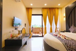 a hotel room with a bed and a television at Chitralekha Boutique Resort in Rājpur