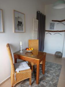 a table and chairs with a bowl of fruit on it at Diavaide Apartment in Dhiavaïdhé