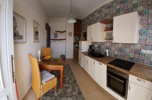 a kitchen with white cabinets and a wooden table at Diavaide Apartment in Dhiavaïdhé