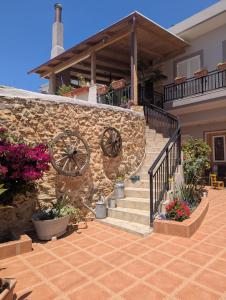 a house with a stone wall and stairs with flowers at Diavaide Apartment in Dhiavaïdhé