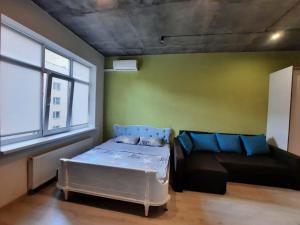 a small room with a bed and a couch at Квартира по улице Коновальца, 36-Э in Kyiv