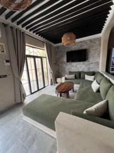 Agadir Bou Settaにあるvilla oasis bourassのベッドルーム(大きな緑のベッド1台、ソファ付)