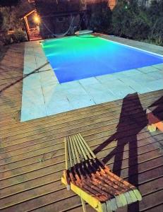 a bench sitting in front of a swimming pool at Cabaña jacaranda in Valle Hermoso