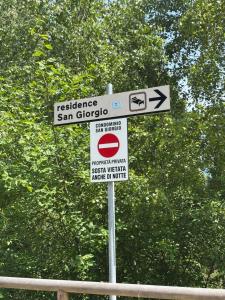 a street sign with several signs on a pole at Chalet dello gnomo in Folgarida +51 photos