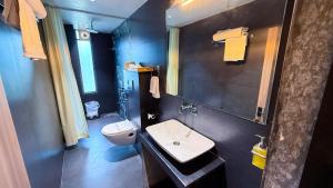 a bathroom with a white toilet and a sink at Aarambh By The Sky Imperial, Nathdwara in Nāthdwāra