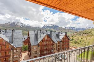 eine Gruppe von Gebäuden mit Bergen im Hintergrund in der Unterkunft Collado, terraza con vistas y garaje - Arafita Apartamentos in Formigal
