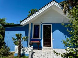 a blue and white house with a door at Коттедж в саду роз in Chakvi