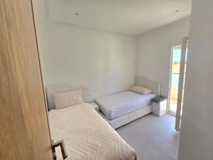 a small bedroom with two beds and a window at Appartement mirador golf 3 in Cabo Negro +16 photos