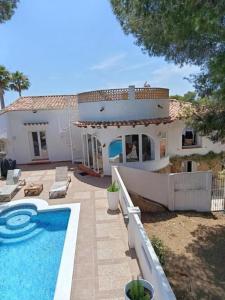 a house with a swimming pool in front of it at Villa les Pins in Jávea