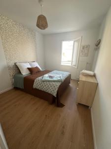 a bedroom with a bed and a wooden floor at Maison Stella in Saint-Georges-dʼOléron