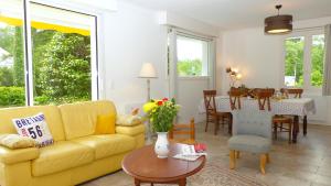 a living room with a yellow couch and a table at Arradon, maison de vacances familiale à 2 km des plages in Arradon +31 photos