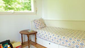 a small bedroom with a bed and a table at Arradon, maison de vacances familiale à 2 km des plages in Arradon