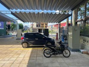 una motocicleta estacionada en una gasolinera con un auto en Khách Sạn Gia Hưng, en Ninh Binh