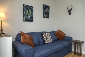 a blue couch in a living room with pillows on it at Joymount Cottage, Carrickfergus - 2 bedroom in Carrickfergus