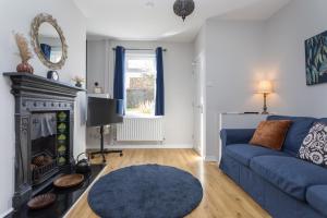 a living room with a blue couch and a fireplace at Joymount Cottage, Carrickfergus - 2 bedroom in Carrickfergus