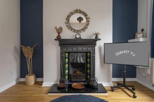 a fireplace in a living room with a mirror at Joymount Cottage, Carrickfergus - 2 bedroom in Carrickfergus