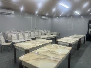 una habitación con filas de escritorios y sillas blancas en Khách Sạn Gia Hưng, en Ninh Binh