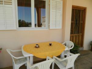 a table and chairs with a yellow table and a window at Bartulovi dvori in Poljica