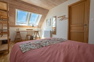 a bedroom with a bed with a red bedspread at Le 50 Bis - Proche plage in Locmiquélic