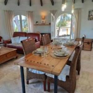 a living room with a wooden table and chairs at Villa les Pins in Jávea