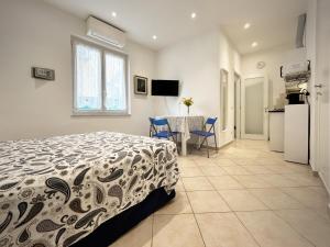 a bedroom with a bed and a table and a kitchen at L'ONDA 3 Portovener-Fezzano in Fezzano