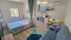 a small room with a bed and a couch and a table at Lennida Studio Apartman with free parking in Kavran