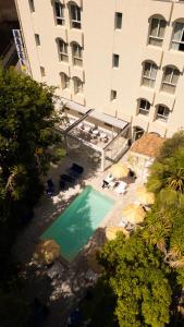 an overhead view of a swimming pool in front of a building at Hôtel Le Sud in Juan-les-Pins
