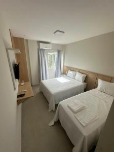 ein Hotelzimmer mit zwei Betten und einem Fenster in der Unterkunft Hotel Sierra in Cuité