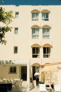 a man standing in front of a building at Hôtel Le Sud in Juan-les-Pins