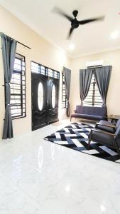 a living room with a couch and a ceiling fan at Rhuteng Homestay in Setiu