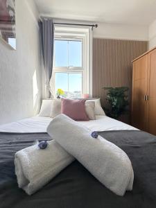 a bedroom with a bed with two towels on it at The Bournemouth Hideaway - Beautiful Central flat - 10 mins walk to beach - Brought to you by Coastline Retreats in Bournemouth