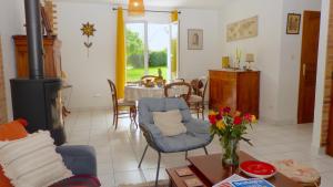 ein Wohnzimmer mit Kamin und Tisch in der Unterkunft Maison proche de la rivière du Bono, entre Auray et Vannes in Plougoumelen