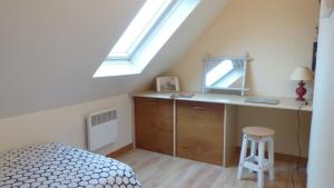 ein Schlafzimmer mit einem Bett und einem Schreibtisch mit Spiegel in der Unterkunft Maison proche de la rivière du Bono, entre Auray et Vannes in Plougoumelen