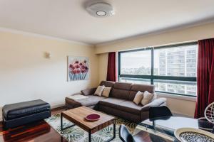 a living room with a couch and a large window at Spacious 1BR with Parking in Quiet Area in Vila Nova de Gaia