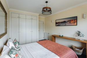 a bedroom with a bed with white cabinets at Spacious 1BR with Parking in Quiet Area in Vila Nova de Gaia