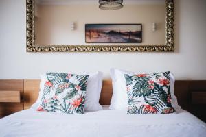 a bedroom with a bed with pillows and a mirror at Spacious 1BR with Parking in Quiet Area in Vila Nova de Gaia