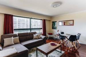 a living room with a couch and a table at Spacious 1BR with Parking in Quiet Area in Vila Nova de Gaia +16 photos