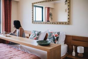 a woman sitting on a bed in front of a mirror at Spacious 1BR with Parking in Quiet Area in Vila Nova de Gaia