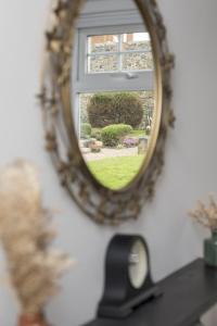 a mirror reflection of a window with a view of a yard at Joymount Cottage, Carrickfergus - 2 bedroom in Carrickfergus