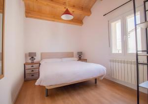 una camera da letto con un letto bianco e una finestra di La Casa del Maestro a Cerezo de Abajo