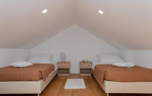 twee bedden in een kamer met witte muren en houten vloeren bij Villa Primabella -Makarska by Villas Guide in Novak +18 foto's