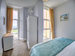 a bedroom with a bed and a large window at Apartment 2 - 1 Bedroom Sea Front-Sea Views-Free Parking in Paignton