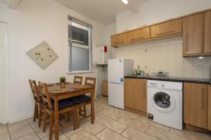 a kitchen with a table and a washing machine at Albert Lodge in Belfast