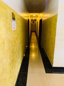 a hallway with yellow walls and a no smoking sign at DF HÔTEL Plazza in Yaoundé