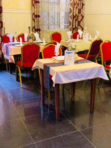 a row of tables with red chairs and tablesearcher at DF HÔTEL Plazza in Yaoundé